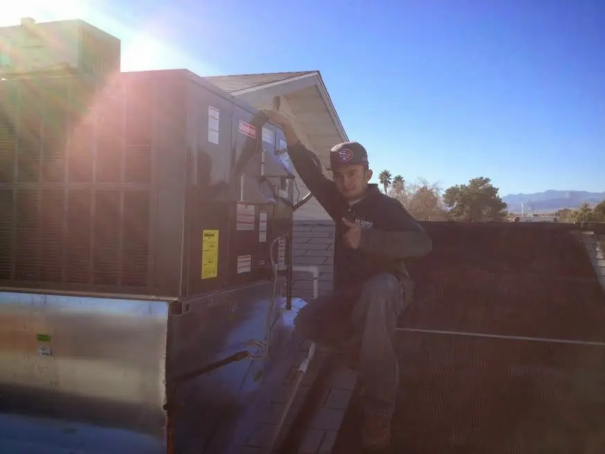 HVAC technician performing Heat Pump Repair on a rooftop unit in Loudon